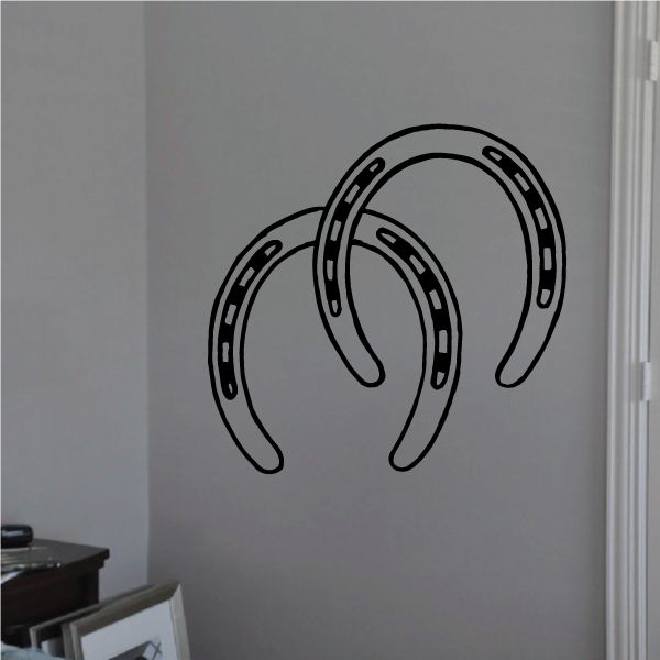 Double horseshoe decal, black outlined horseshoe shapes on a light surface