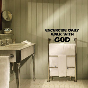 Wall decal with "Exercise daily walk with God" lettering above bathroom towels