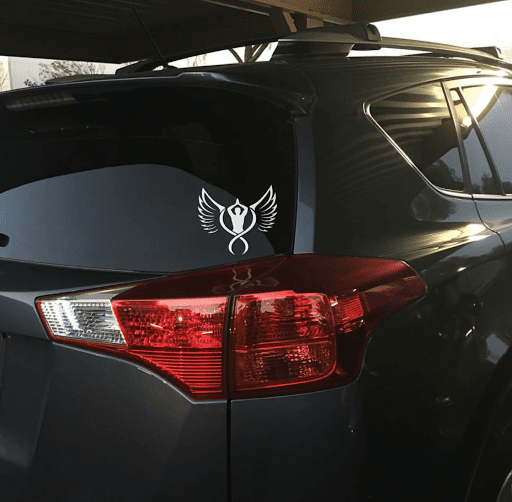 Vehicle decal with white winged heart emblem on dark car door panel