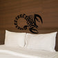 Black crawling scorpion wall decal with tribal style design above pillows