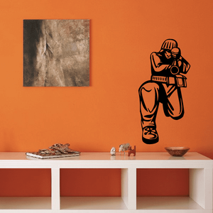 Front view paintball player decal with black and orange outline on wall