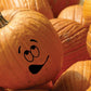 Goofy pumpkin face decal with black smiling eyes and mouth on orange pumpkin