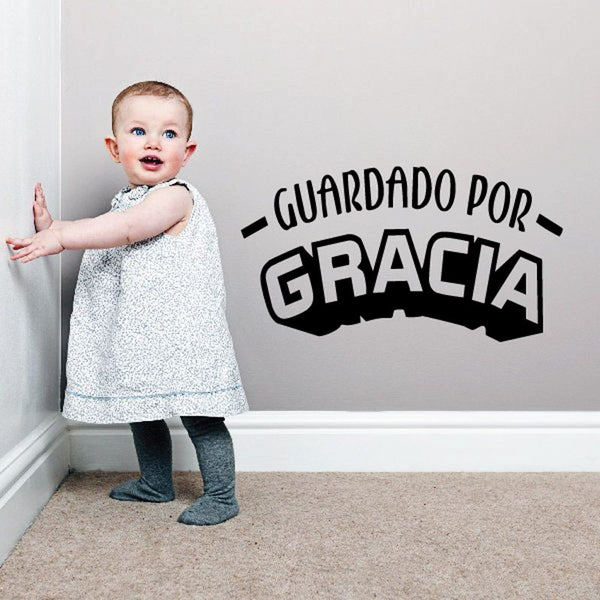 Wall decal text: "GUARDADO POR GRACIA" in bold black lettering