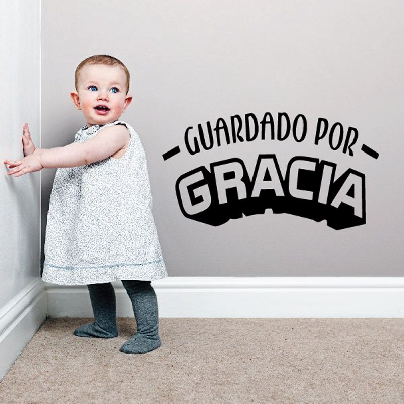 Wall decal text: "GUARDADO POR GRACIA" in bold black lettering