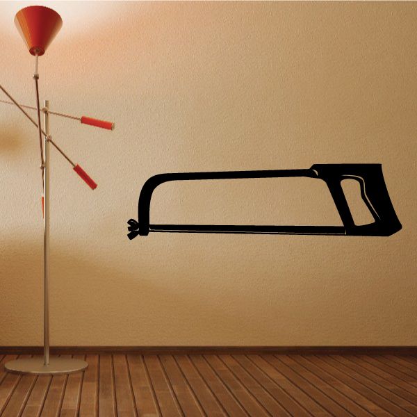 Large hack saw wall decal, black silhouette with angled handle and blade teeth.