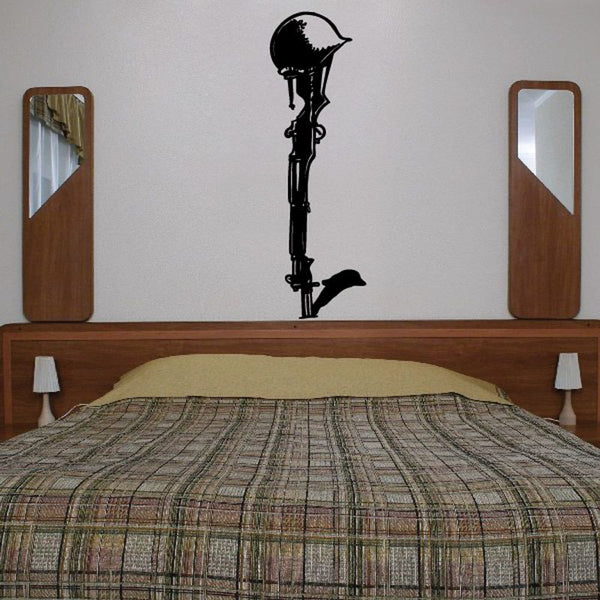 Black cross wall decal with small dove silhouette, centered above bed