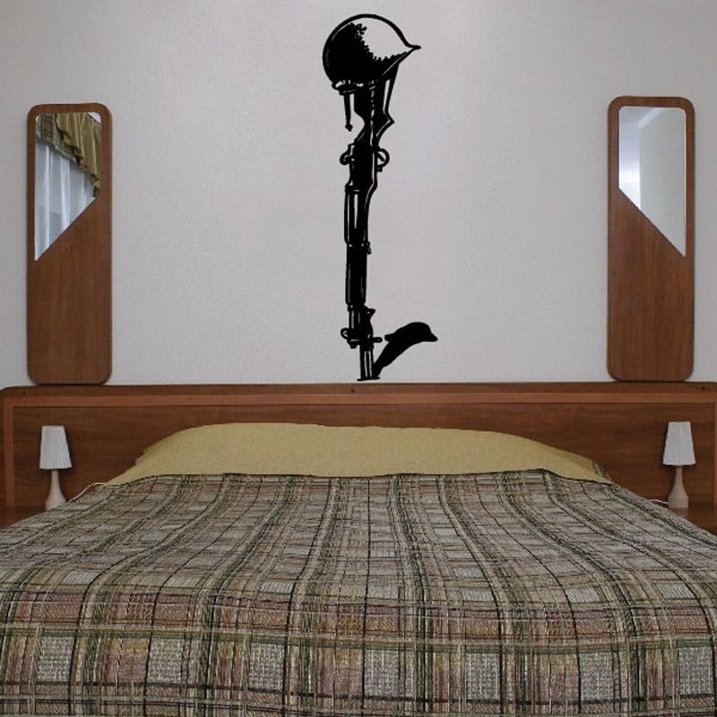 Black cross wall decal with small dove silhouette, centered above bed