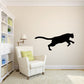Black pouncing mountain lion wall decal with long tail and open mouth
