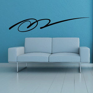 Southwestern vinyl wall decal with black swirl motif on blue wall above sofa