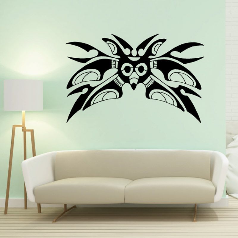 Black moth wall decal with detailed wings, centered above sofa