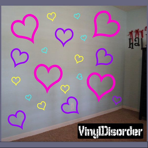 Outlined heart wall decals in neon pink, purple, blue and yellow on a wall