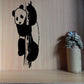 Black-and-white panda climbing wall decal with paws raised and tail.
