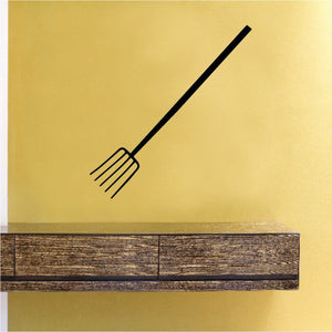 Pitch fork decal with black fork outline on a light yellow wall