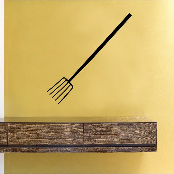 Pitch fork decal with black fork outline on a light yellow wall