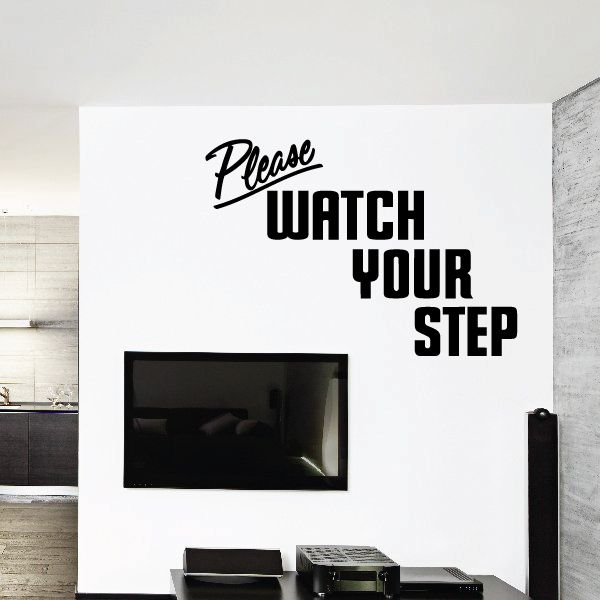 Wall decal with “Please WATCH YOUR STEP” in black and white lettering