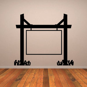 Black vinyl wall decal of rectangular frame with two posts and flanking leaf silhouettes.