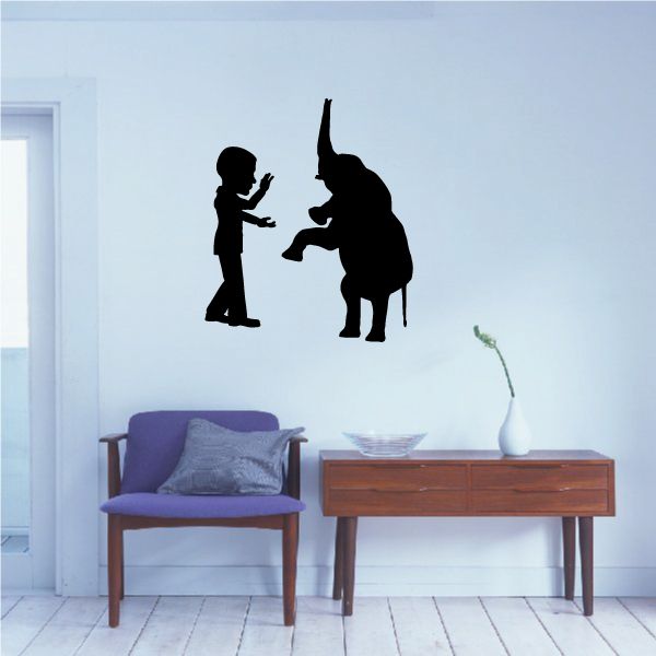 Silhouette wall decal of a person playing with an elephant