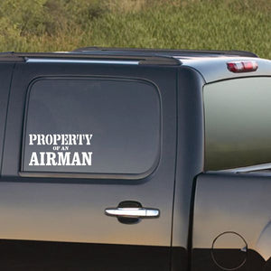 Property of an Airman decal with white text on dark car window