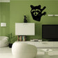 Raccoon looking over wall decal with black and green face, paws raised