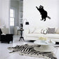 Black raccoon wall decal, hind legs reaching upward with paws extended