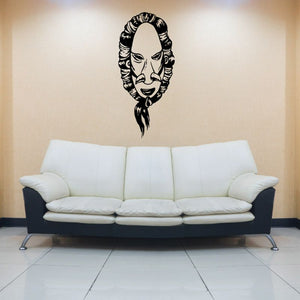 Tribal mask wall decal with black detailed face design above white sofa