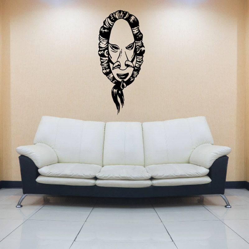 Tribal mask wall decal with black detailed face design above white sofa