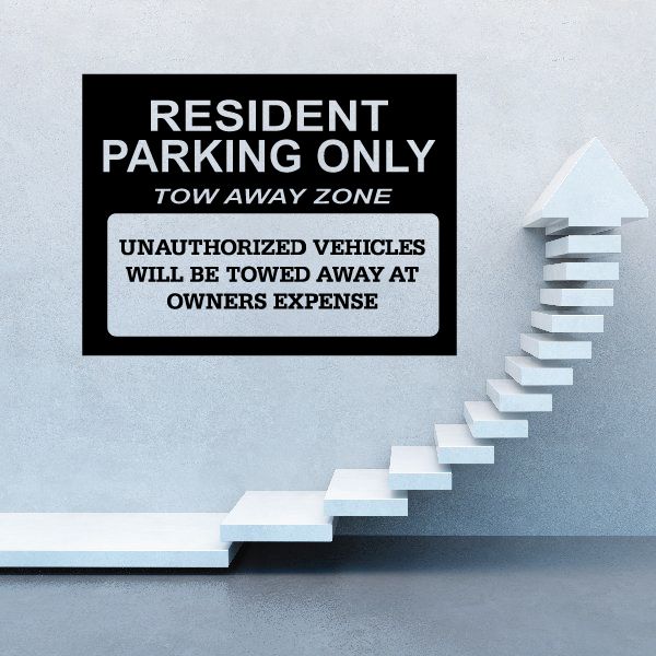 Parking tow away zone wall decal, black sign with white text and right arrow on wall