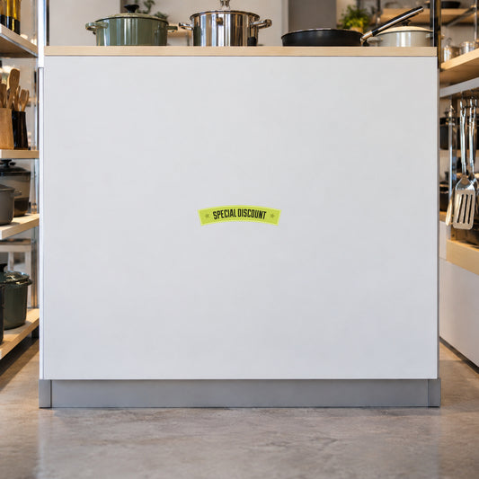 White square discount sign with small green sticker label centered