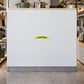 Special Discount Retail Discount Sign Sticker applied in A blank smooth white display cabinet front in a small kitchenware store, cookware above top edge and utensils only extreme sides.