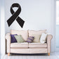 Black awareness ribbon decal on wall above a sofa