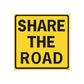 Yellow road sign sticker with black border reading "SHARE THE ROAD".