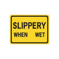 Yellow road sign sticker with black border, text "SLIPPERY WHEN WET".