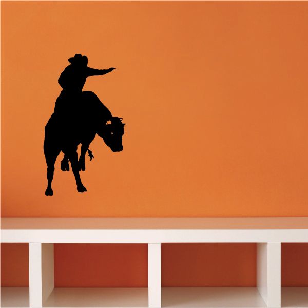 Rodeo bull riding wall decal with black silhouette of cowboy and bull.