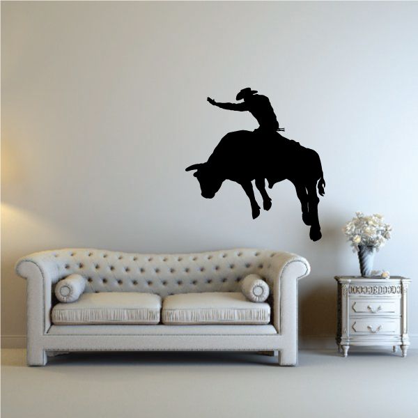 Bull riding wall decal of a black rider on a bucking bull silhouette.