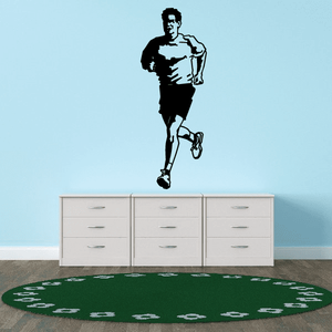 Runner wall vinyl decal with black silhouette and sneaker footprints on green base
