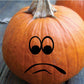 Orange pumpkin face decal with black teary eyes and frowning mouth