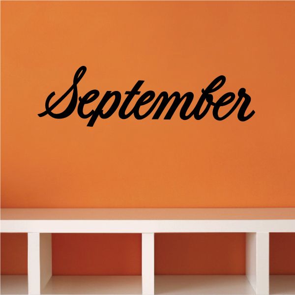 September wall decal with black cursive "September" lettering on orange surface