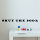 Black wall decal with large text "SHUT THE DOOR" in block lettering.