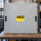 Caution sign sticker with yellow CAUTION text on a white square