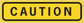 Yellow rectangle caution sticker with black border and CAUTION text