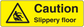 Yellow caution floor sticker: black triangle warning and text 'Caution Slippery floor'.