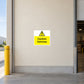 Caution Vehicles Sticker applied in Broad smooth cream entrance wall beside a warehouse vehicle access lane, central wall clear, loading doorway far right and protective bollard at far left.