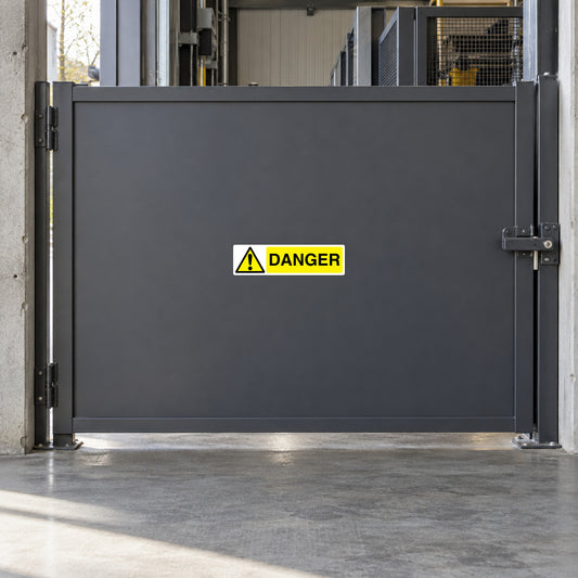 Danger warning sticker on gray metal gate panel
