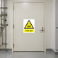 Caution Toxic Gas Sticker applied in Closed cream toxic-gas storage room door in a semiconductor support facility, opaque central face unbroken, lock far right, gas supply pipework only at far left.