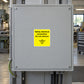 Metal electrical junction box with yellow safety sticker, do not remove.