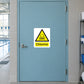 Caution Chlorine Sticker applied in Closed aqua pool chemical storage room door beside an indoor swimming facility, broad unbroken opaque door surface, latch extreme left, pale ceramic tiled jamb and small hint of pool flooring at bottom.