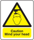 Warning sticker: yellow triangle with head icon and "Caution Mind your head" text
