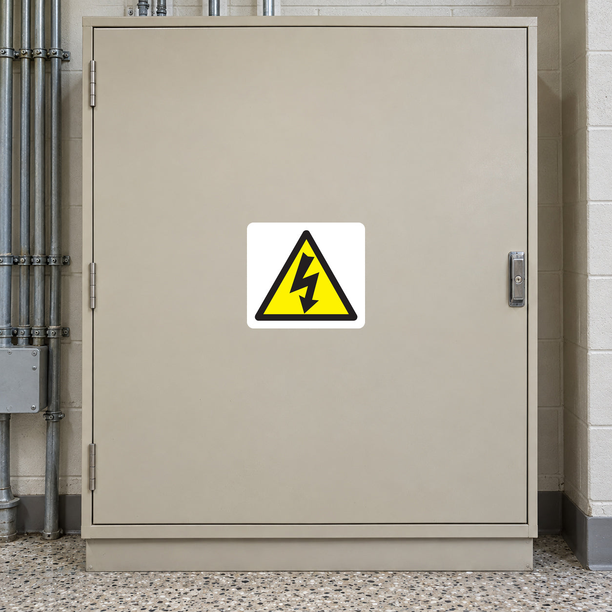 Caution Electricity Sticker applied in Closed pale tan electrical distribution cabinet in a school utility room, broad central single front door, latch at extreme right, terrazzo floor at bottom and conduits at outer left.