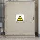 Caution Electricity Sticker applied in Closed pale tan electrical distribution cabinet in a school utility room, broad central single front door, latch at extreme right, terrazzo floor at bottom and conduits at outer left.