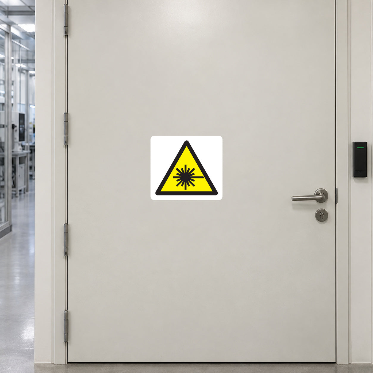 Laser warning sticker with yellow triangular hazard symbol and black sunburst icon